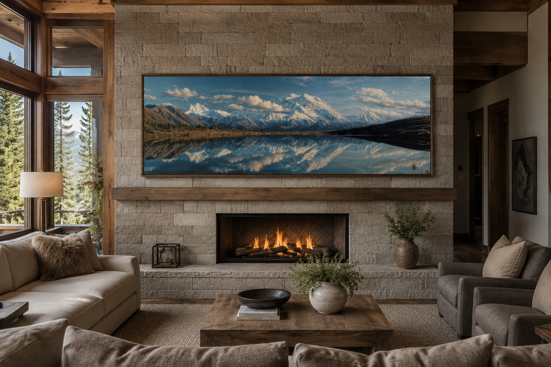 Panoramic wall art of Denali and Wonder Lake reflecting snowy peaks above a stone fireplace.