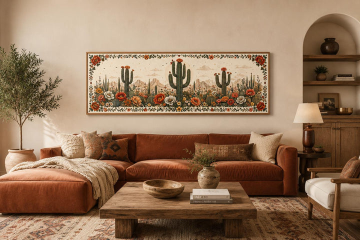 Long narrow canvas wall art of blooming saguaro cacti and desert flowers in a Southwestern room.