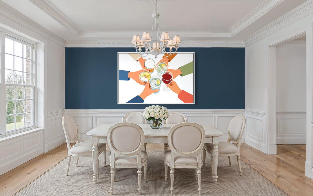 A modern canvas print of friends toasting drinks hangs in a bright, elegant dining room.