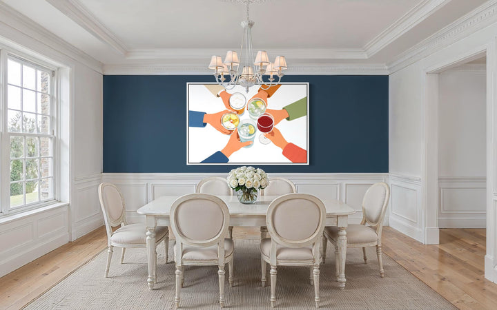 A modern canvas print of friends toasting drinks hangs in a bright, elegant dining room.