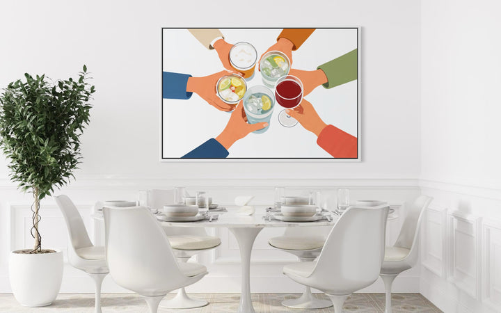 A modern canvas print of friends toasting drinks hangs above a white dining table and chairs.