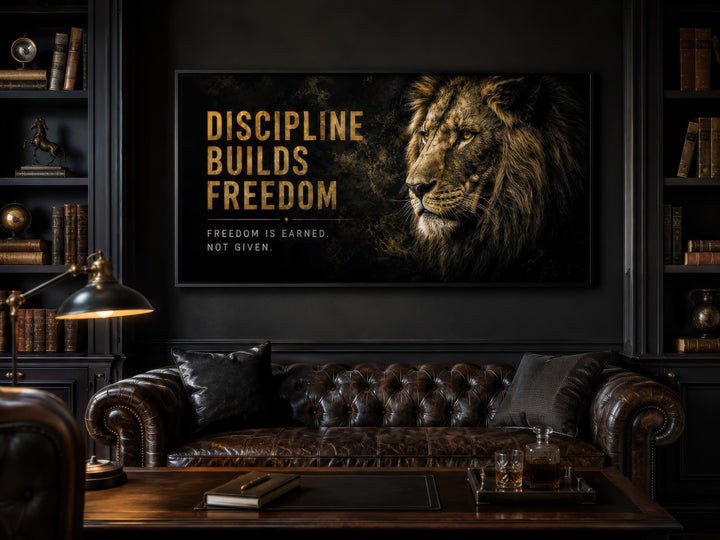 Motivational lion wall art with gold text Discipline Builds Freedom in a dark office setting.