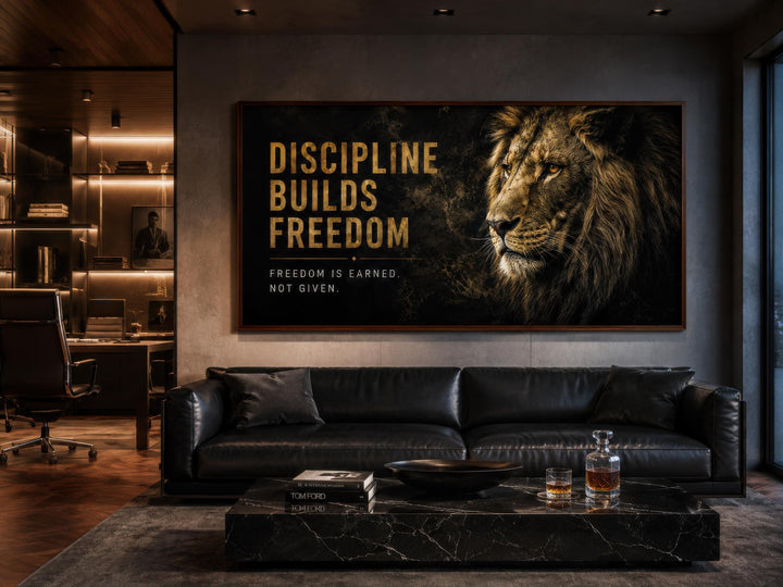 Discipline Builds Freedom motivational lion wall art in a modern office with a black leather sofa.