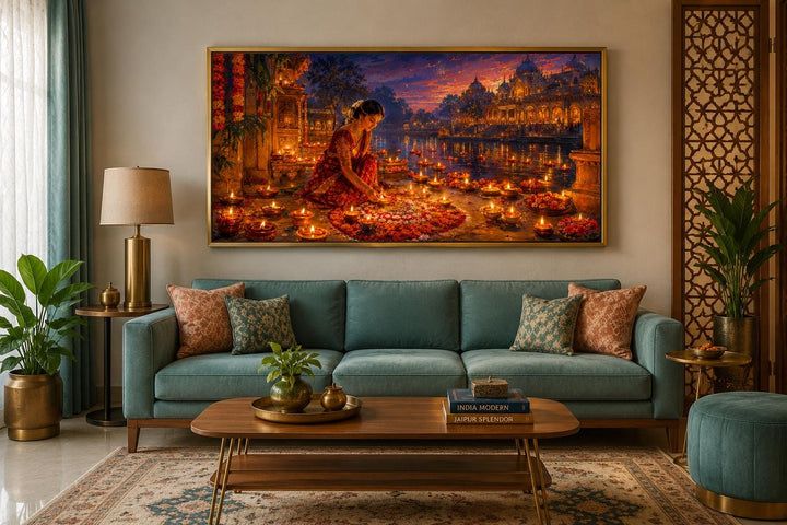 Diwali canvas wall art of a woman lighting diyas, hung above a teal sofa in a living room.
