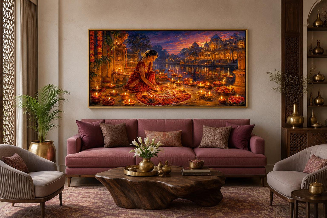 Diwali canvas wall art of a woman lighting diyas, hung above a sofa in a living room.