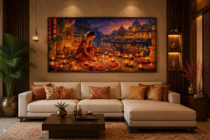 Diwali canvas wall art of a woman lighting diyas, hung above a sofa in a warm living room.
