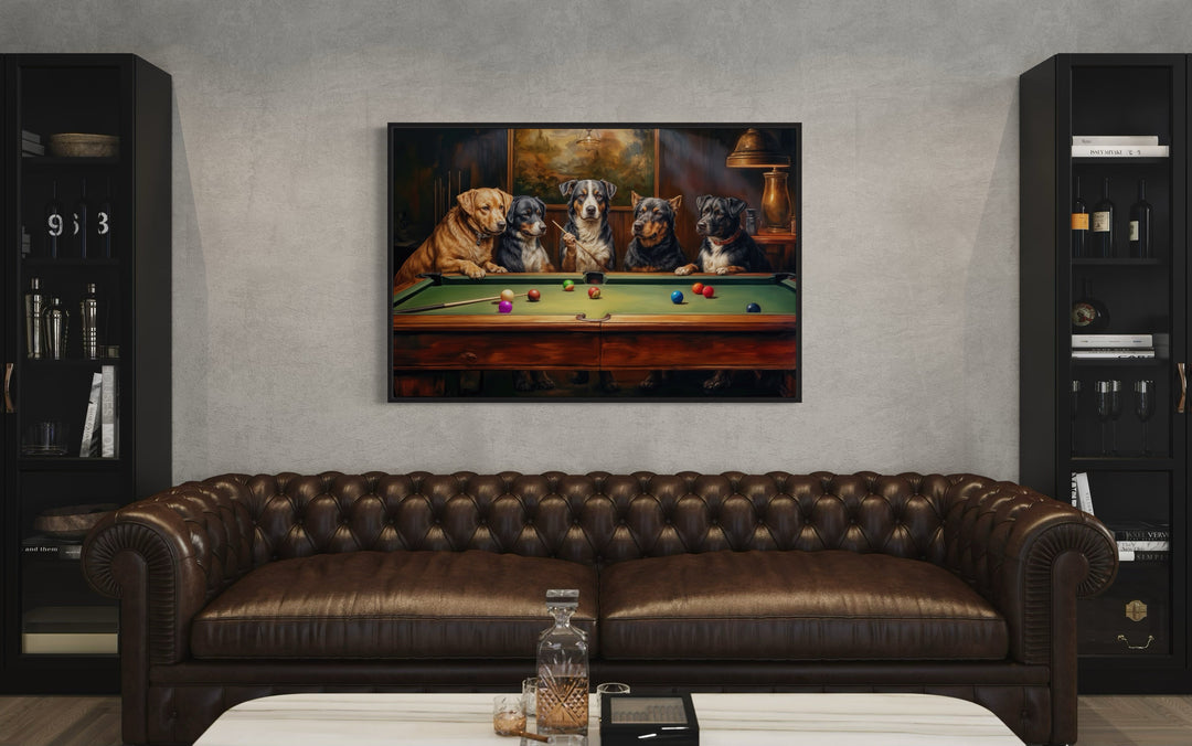Dogs Playing Pool framed canvas wall art hanging above a brown leather sofa in a game room.