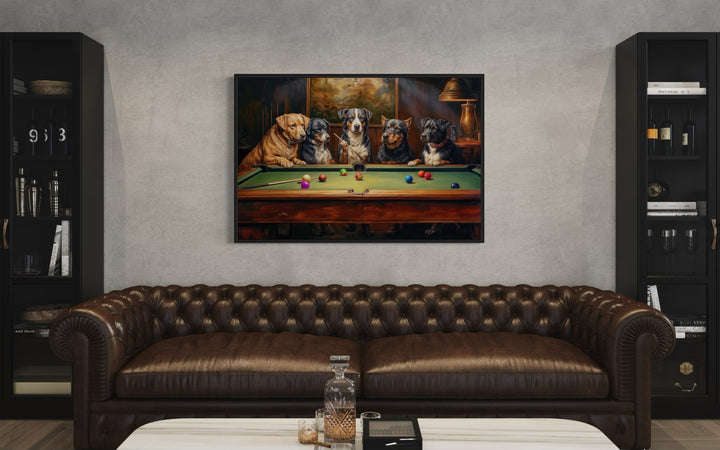 Dogs Playing Pool framed canvas wall art hanging above a brown leather sofa in a game room.