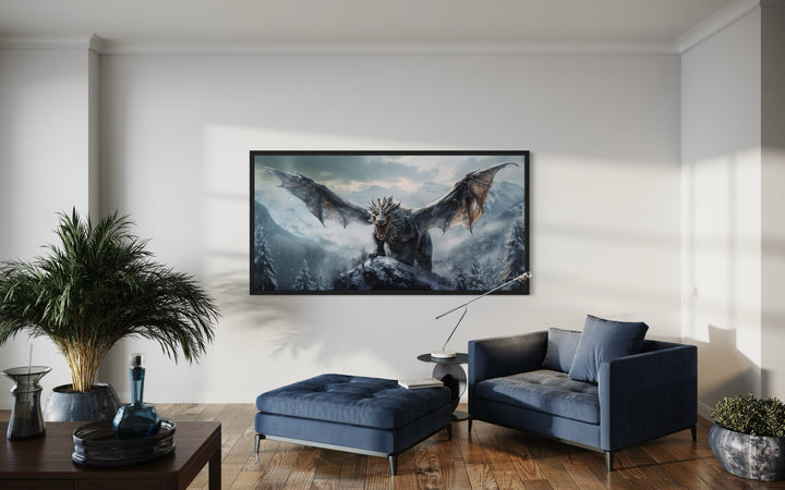 Framed dragon canvas wall art depicting a dragon in snowy mountains above a blue velvet chair.