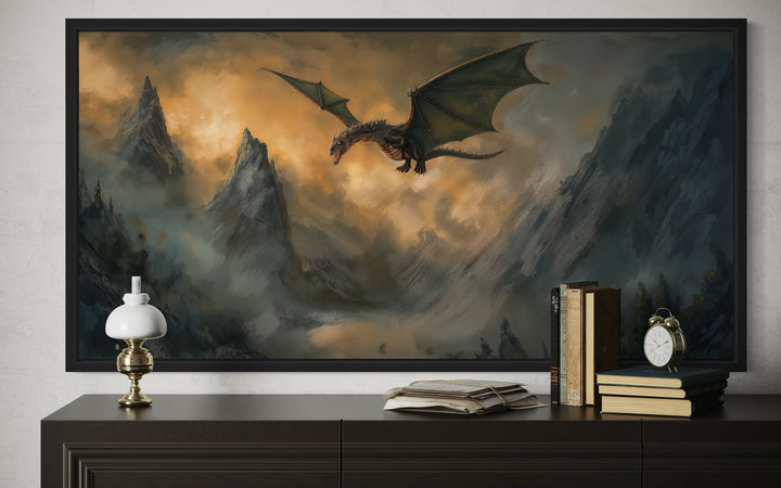 Framed panoramic canvas art of a black dragon flying over misty, rugged mountains at sunset.