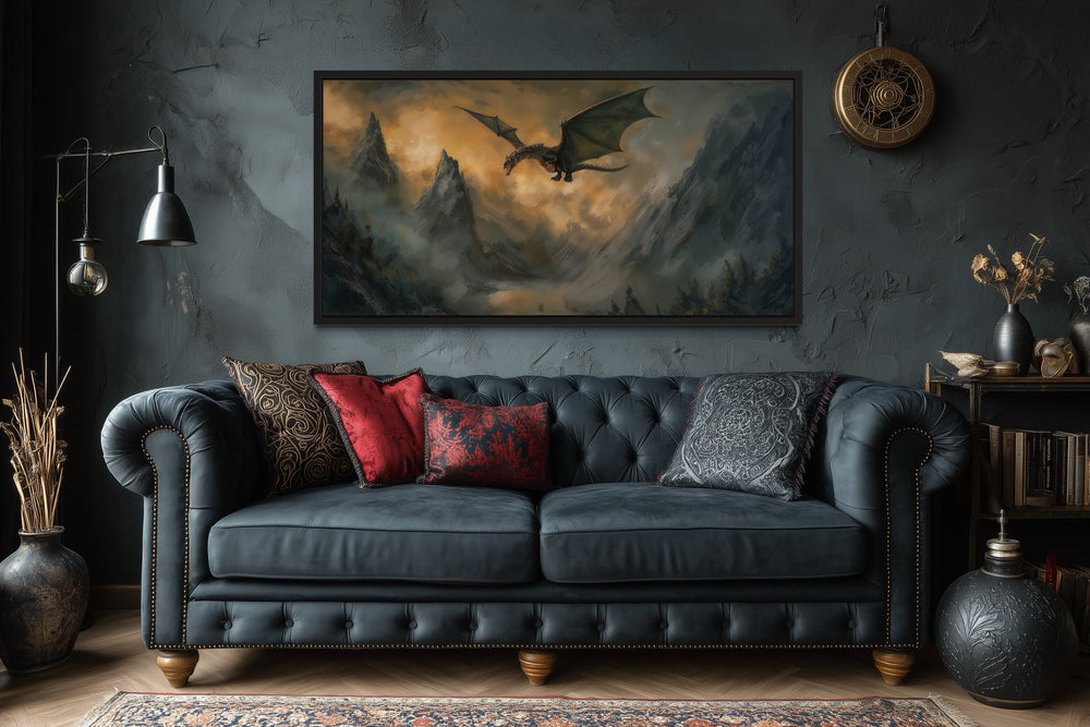 Framed panoramic canvas wall art of a dragon flying over misty mountains above a dark tufted sofa.