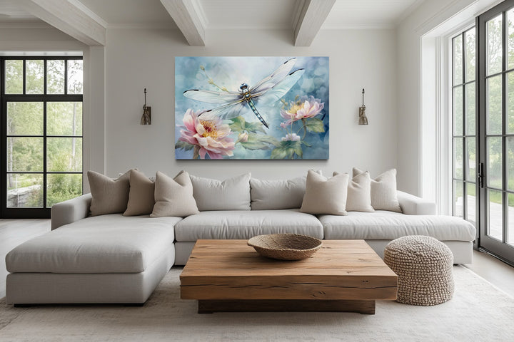 Dragonfly on flower watercolor wall art in a farmhouse living room above a white sectional sofa.