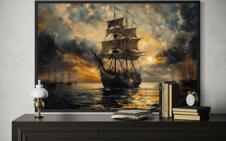 Dramatic black and gold sailing ship canvas wall art in a black frame above a dark credenza.