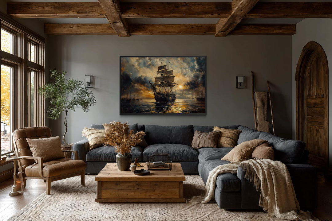 Dramatic black and gold ship framed canvas wall art in a rustic living room above a grey sofa.