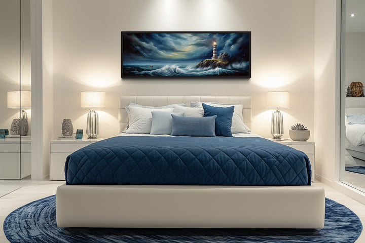 Dramatic long horizontal wall art of a lighthouse in a stormy ocean above a modern bed.