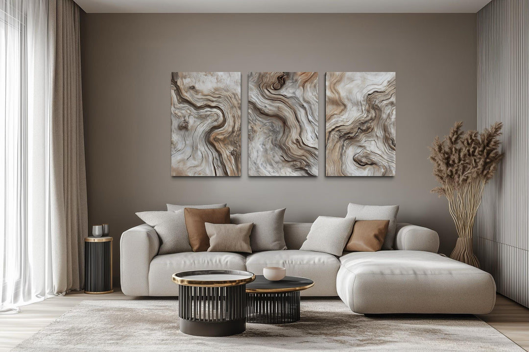 A triptych of vertical canvas wall art featuring abstract driftwood grain patterns in a living room.