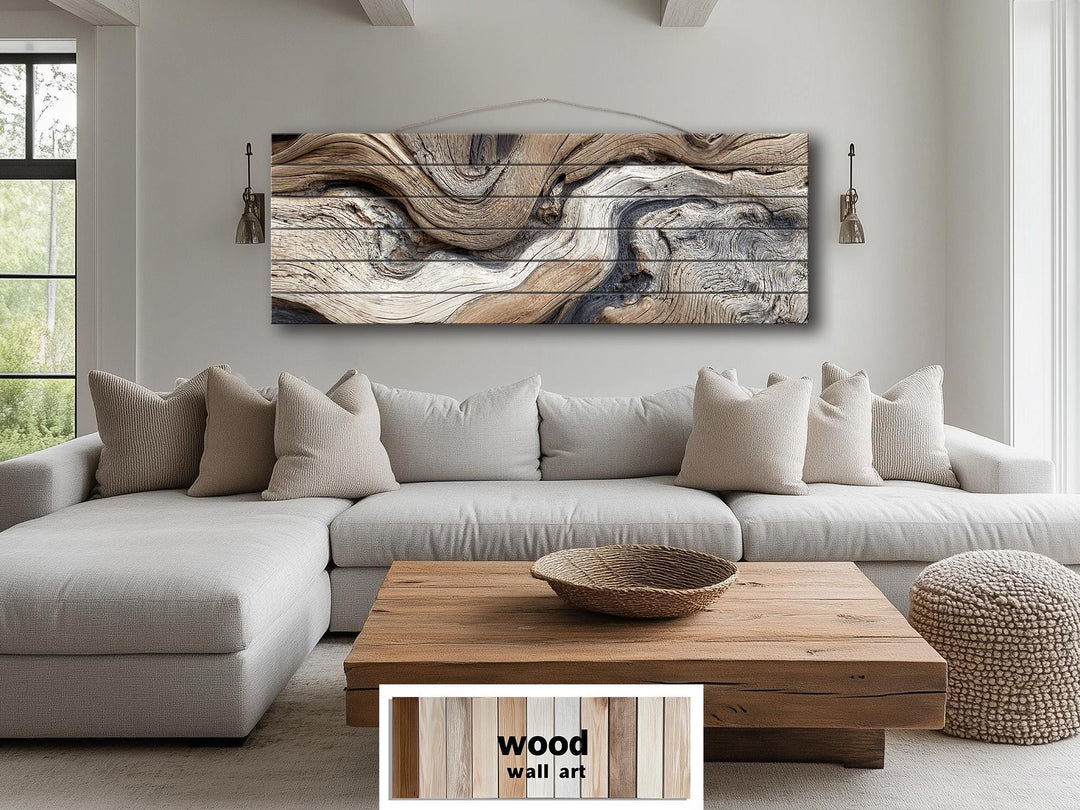 Large horizontal driftwood painting on wood planks above a neutral sofa in a modern living room.