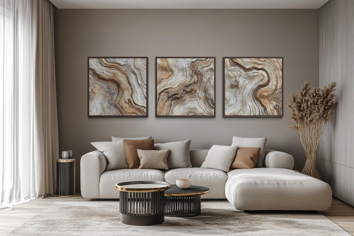 Triptych of driftwood wood grain canvas wall art in a neutral coastal living room.