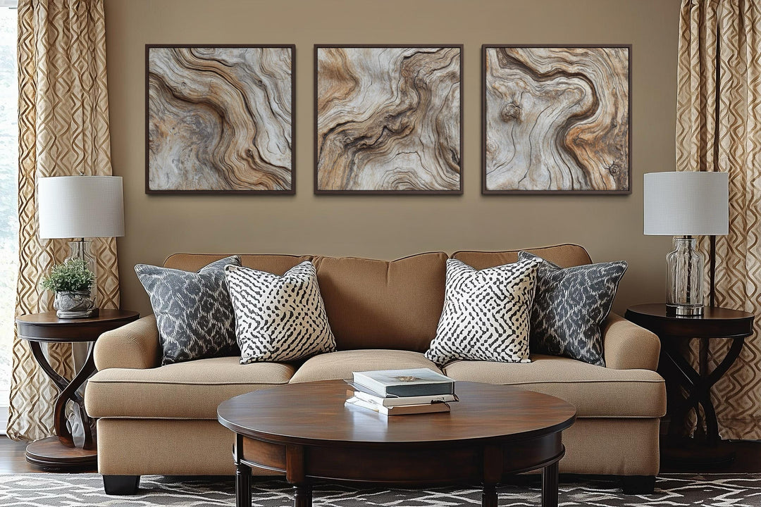 Triptych of three square driftwood wood grain canvas paintings in a warm, neutral living room.