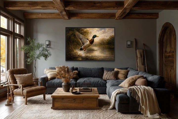 A mallard duck in flight over a river scene canvas print hangs in a rustic living room.