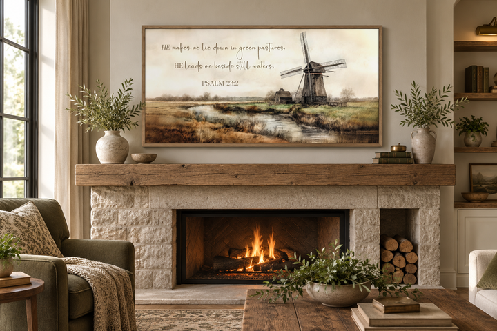 Psalm 23:2 scripture wall art with a windmill landscape above a stone fireplace in a cozy room.