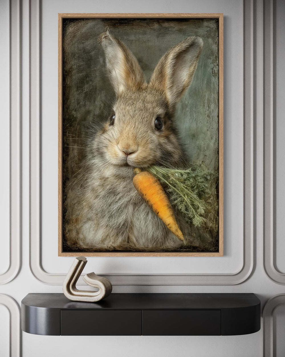 Vintage rabbit canvas print holding a carrot, framed on a wall above a black console table.