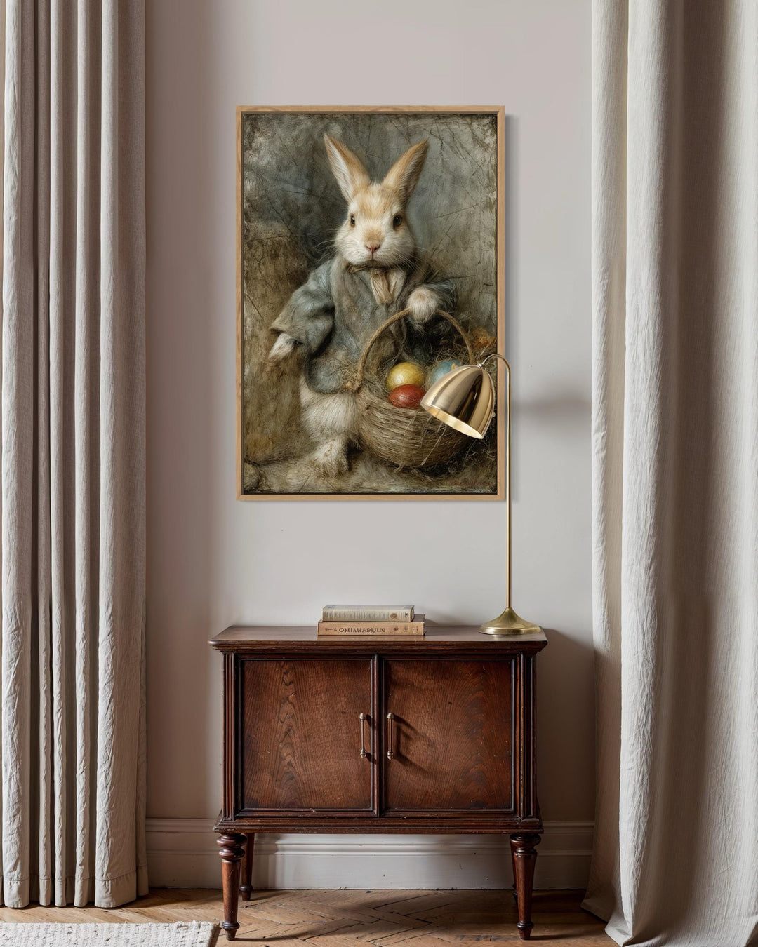 Vintage rabbit painting in a wooden frame above a dark wood cabinet with a gold lamp.