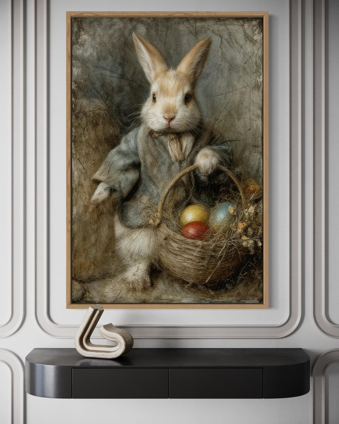 Vintage rabbit painting in a wooden frame featuring a bunny with a basket of Easter eggs.