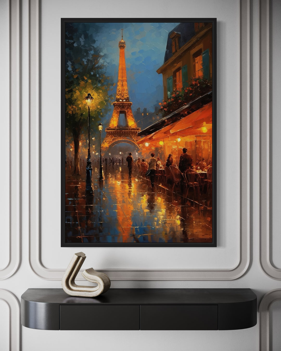 Eiffel Tower and Paris street cafe framed canvas wall art hanging above a black console table.