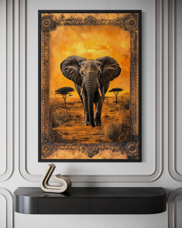 Framed canvas wall art of an elephant in the African savanna at sunset with an ornate border.