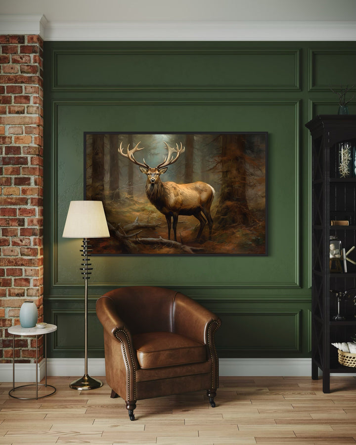 Framed canvas wall art of a majestic elk in a fir forest, styled in a rustic green paneled room.