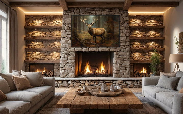 Framed canvas wall art of an elk in a fir tree forest hanging above a rustic stone fireplace.
