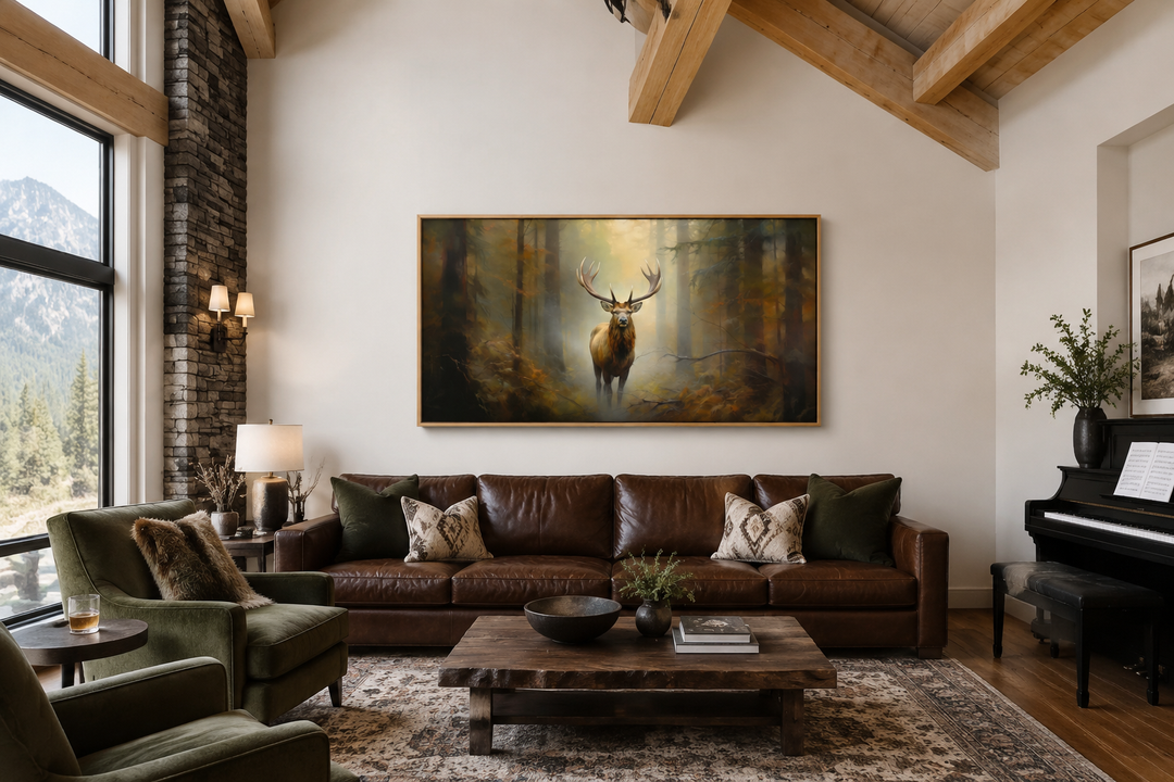 Large framed canvas wall art of a majestic elk in a foggy forest above a brown leather sofa.