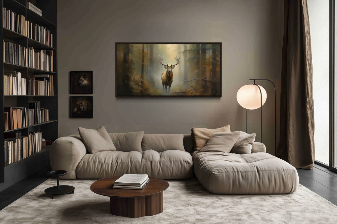 Large framed canvas wall art of a majestic elk in a foggy forest above a modern sofa.