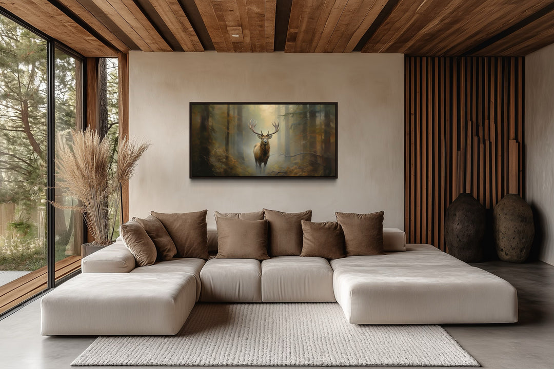 Large framed canvas wall art of a majestic elk in a foggy forest above a modern sectional sofa.