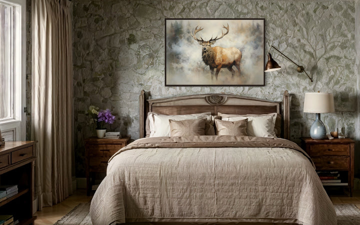 Framed canvas wall art of a majestic elk in a smoky forest above a bed in a rustic stone room.