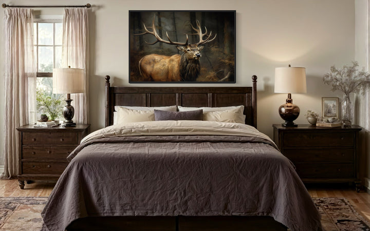 Elk with big antlers in the forest framed canvas wall art hanging above a bed in a rustic bedroom.