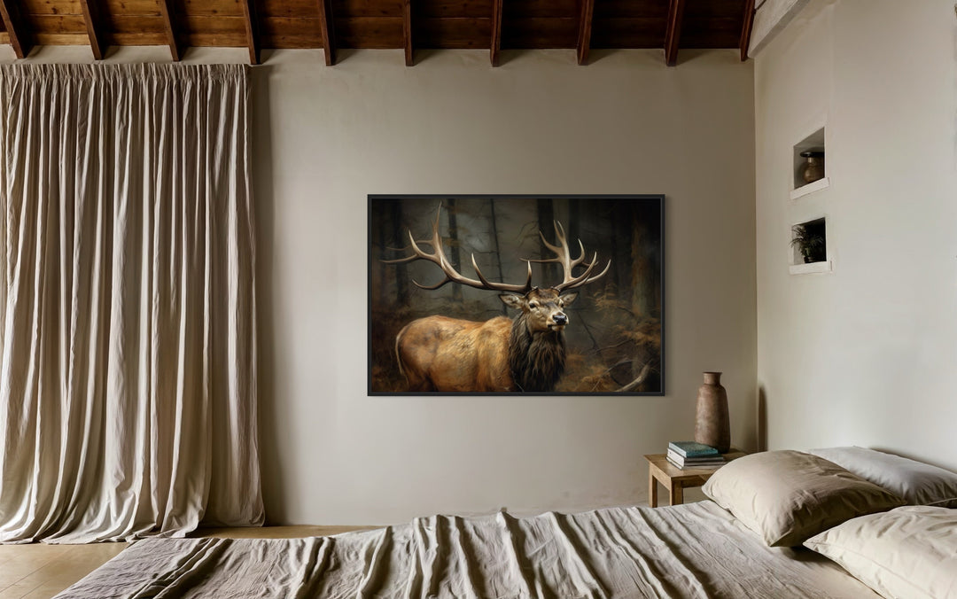 Framed canvas wall art of a majestic elk with large antlers in a dark forest above a bed.