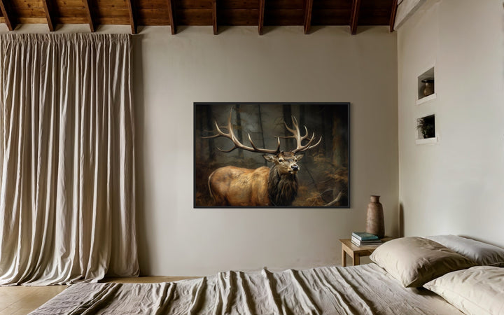 Framed canvas wall art of a majestic elk with large antlers in a dark forest above a bed.