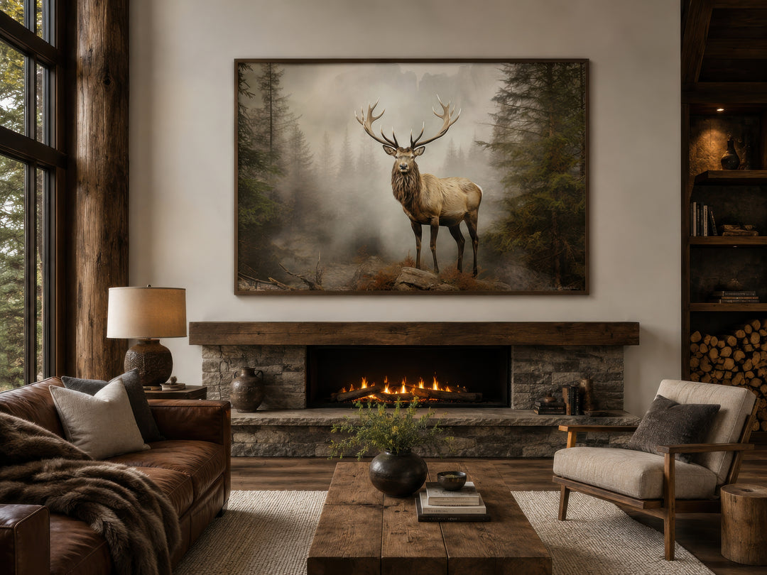 Elk in a misty fir tree forest painting framed above a fireplace in a rustic cabin living room.