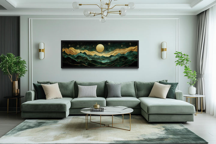 Emerald green and gold panoramic mountain landscape wall art centered above a modern green sofa.