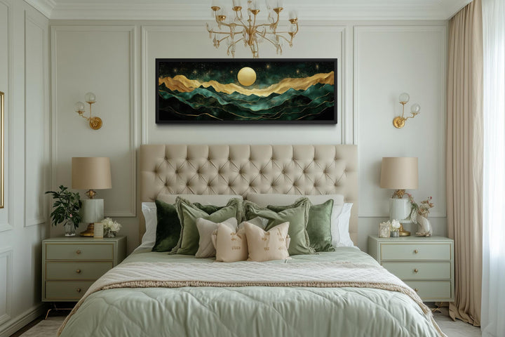 Panoramic emerald green and gold mountain landscape wall art with a moon above a tufted headboard.
