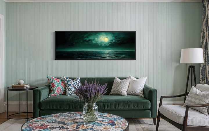 Emerald green ocean seascape with moon over bed wall art in a panoramic black frame.