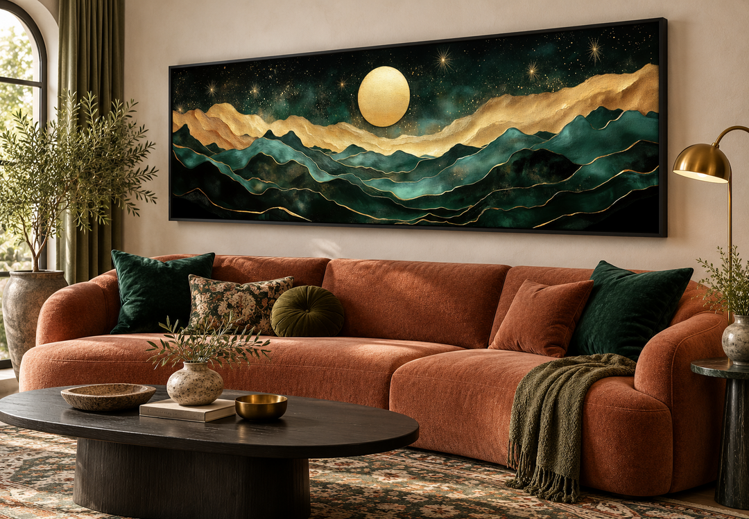 Panoramic emerald green and gold mountain canvas wall art with a moon above a terracotta sofa.