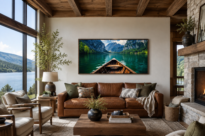 Framed canvas art of a wooden boat on an emerald green lake above a brown leather sofa.