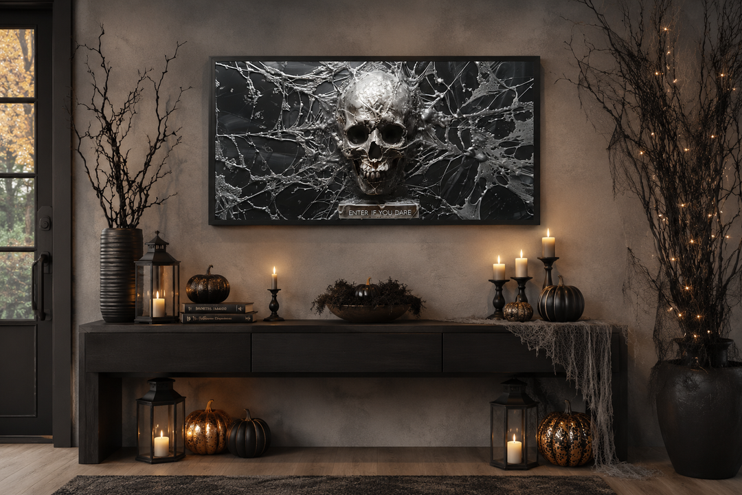 Framed black and white skeleton skull and spiderweb wall art above a Halloween-themed console table.
