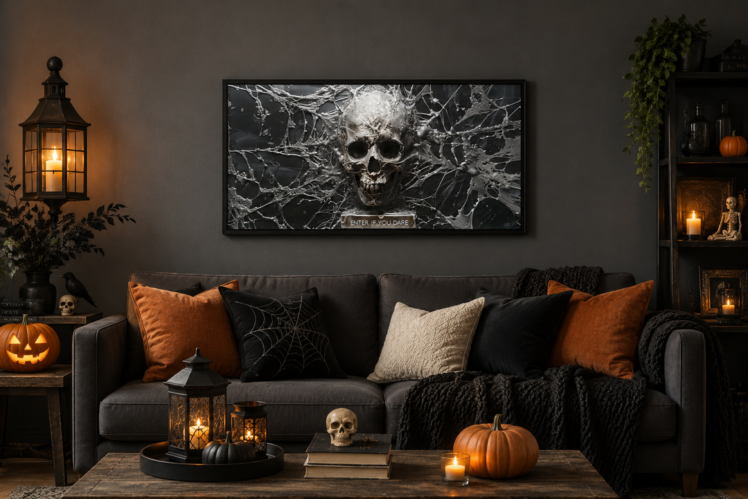 Framed black and white skeleton skull with spiderweb wall art above a sofa with Halloween decor.