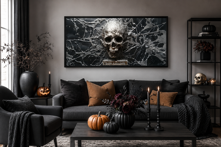 Gothic wall art featuring a metallic skull in a spiderweb above a sofa with Halloween decorations.