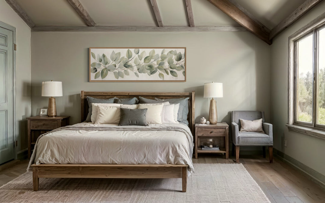 Eucalyptus leaves painted on rustic wood long horizontal framed canvas wall art above a bed.