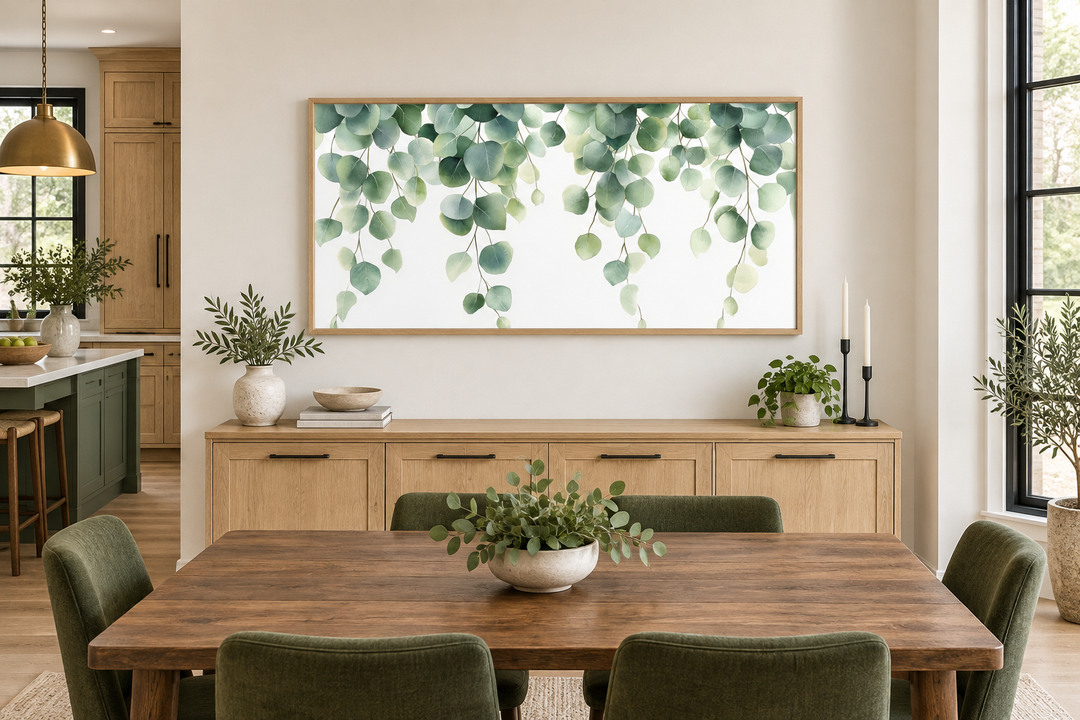 Horizontal framed canvas wall art featuring cascading sage green eucalyptus leaves on a white base.